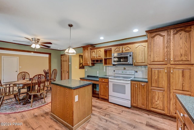 kitchen featuring ornamental molding, pendant lighting, a center island, light hardwood / wood-style floors, and range with electric stovetop