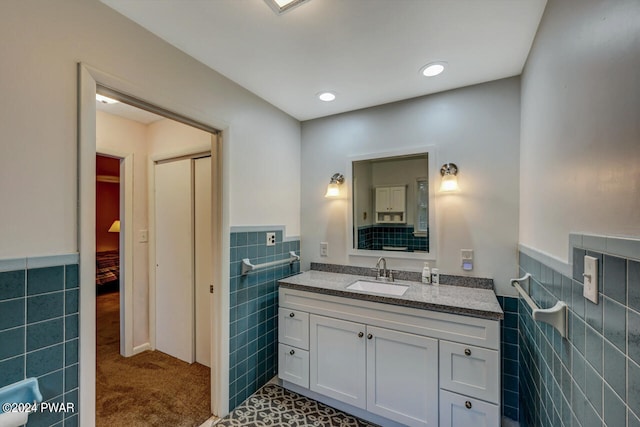 bathroom with vanity and tile walls