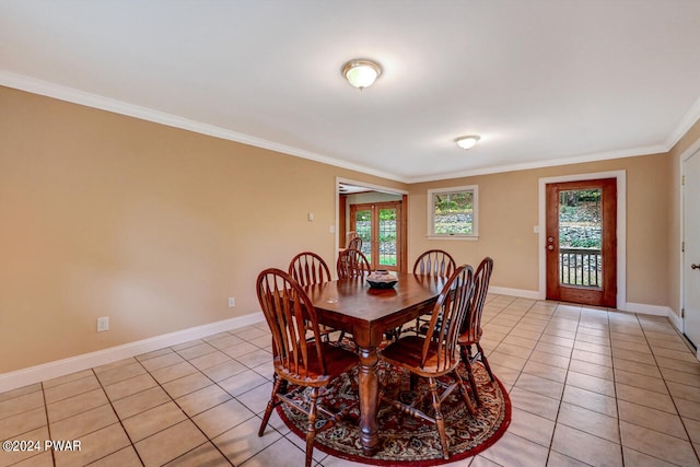 tiled dining area featuring crown molding and french doors