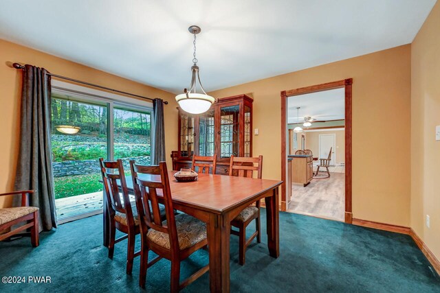 dining room with ceiling fan and dark carpet