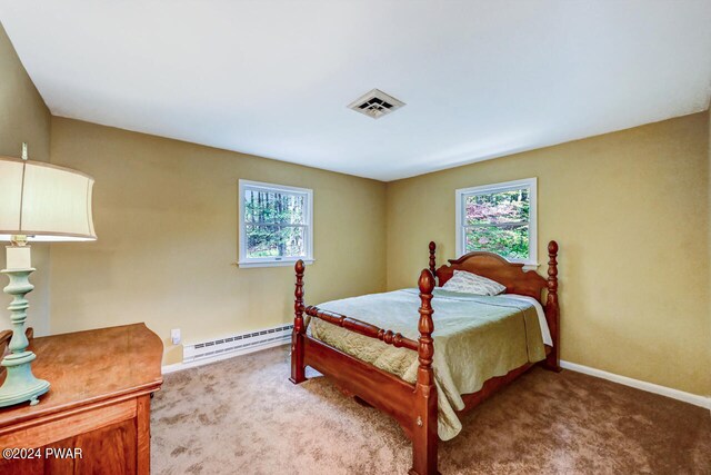 carpeted bedroom featuring baseboard heating