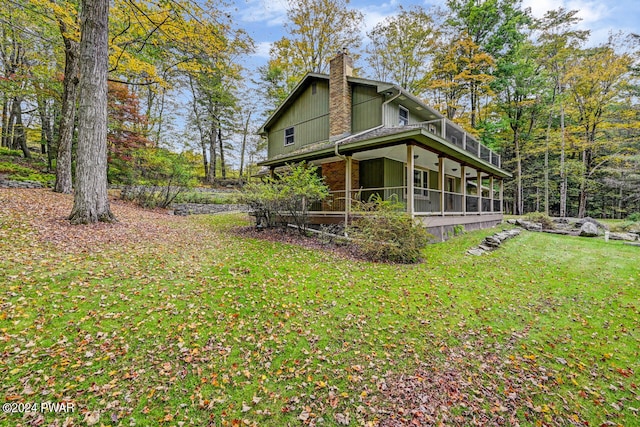 view of home's exterior featuring a sunroom and a yard