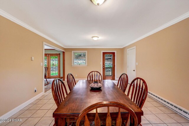 dining space with light tile patterned floors, ornamental molding, and a baseboard heating unit