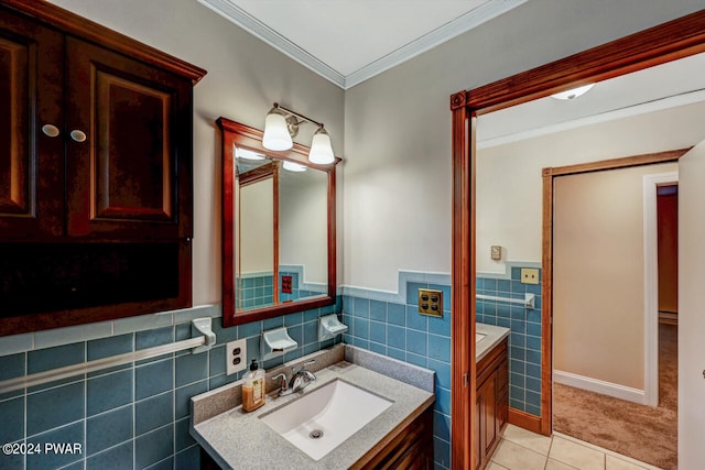 bathroom with tile patterned floors, vanity, crown molding, and tile walls