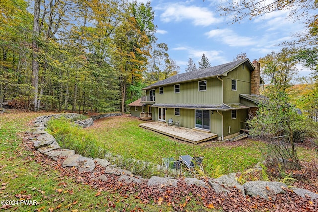 back of house with a deck and a yard