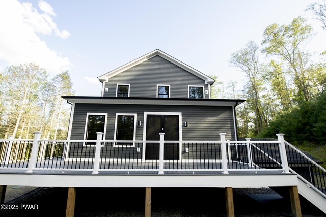 rear view of property featuring a wooden deck