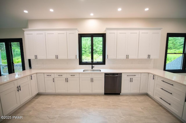 kitchen with dishwashing machine, plenty of natural light, a peninsula, and a sink