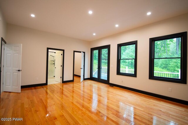 unfurnished room with recessed lighting, french doors, and light wood-style flooring