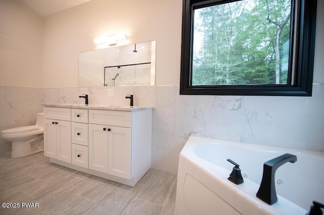 full bathroom featuring toilet, double vanity, a bath, tile walls, and a sink