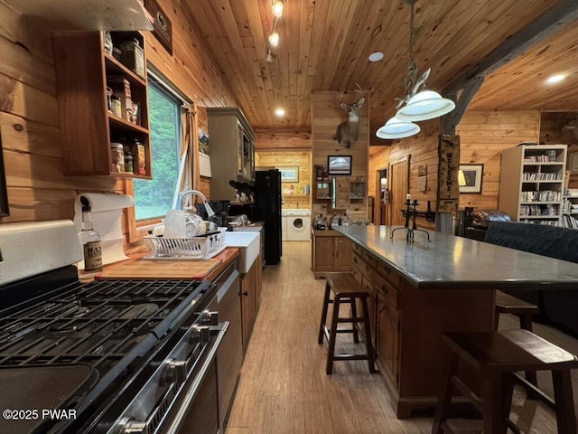 498 Penn York Rd, Starlight, PA 18461 - kitchen featuring stainless steel gas stove, washer / clothes dryer, wooden ceiling, wooden walls, and a kitchen breakfast bar