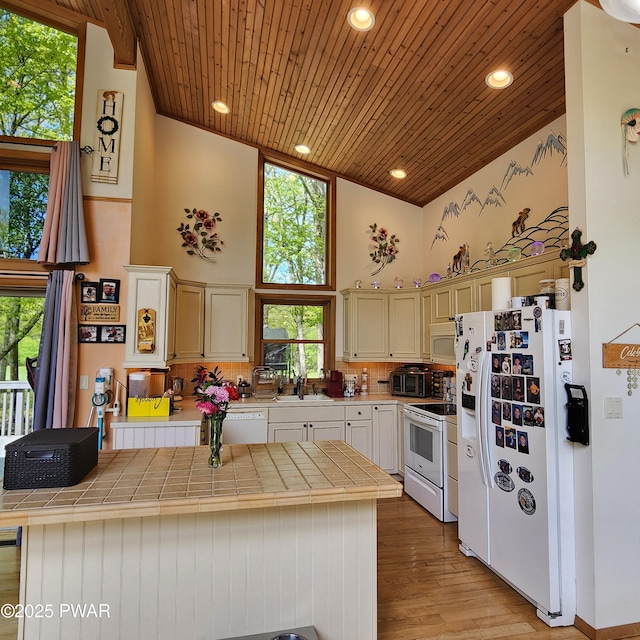 344 Canoebrook Dr, Lords Valley, PA 18428 - kitchen with white appliances, tile counters, high vaulted ceiling, wooden ceiling, and backsplash