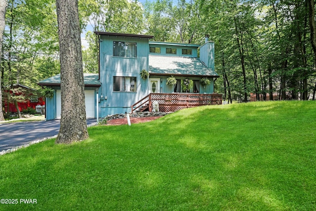 103 Westfall Dr, Dingmans Ferry, PA 18328 - view of front facade featuring driveway, a chimney, a front yard, and a garage