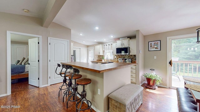 142 Myck Rd, Dingmans Ferry, PA 18328 - kitchen with appliances with stainless steel finishes, butcher block counters, wood finished floors, a kitchen island, and a kitchen bar