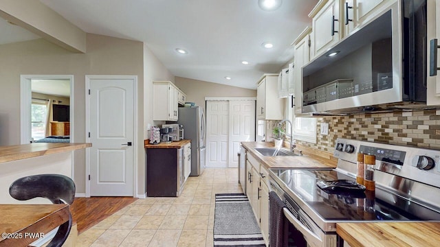 142 Myck Rd, Dingmans Ferry, PA 18328 - kitchen with appliances with stainless steel finishes, vaulted ceiling, butcher block countertops, decorative backsplash, and recessed lighting