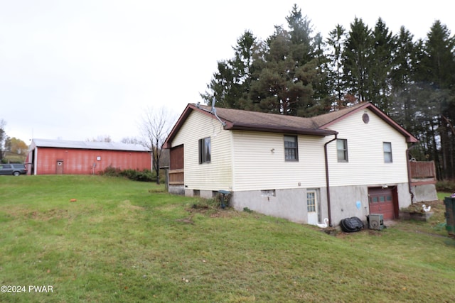 view of side of home featuring central AC, a garage, and a lawn