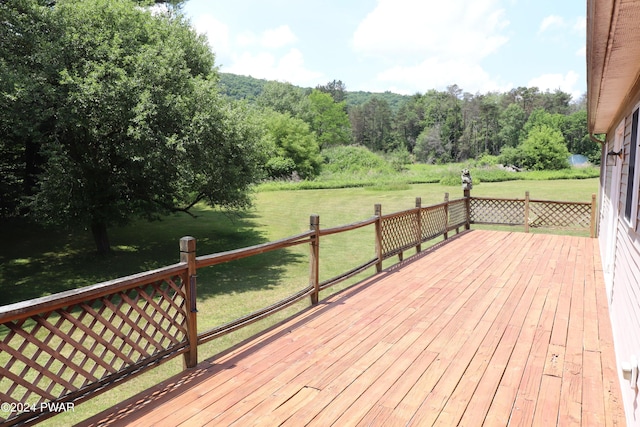 wooden terrace featuring a lawn