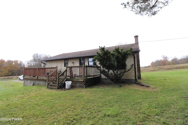 back of property with a deck and a yard