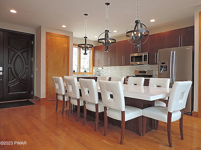 dining space with wood-type flooring and a notable chandelier