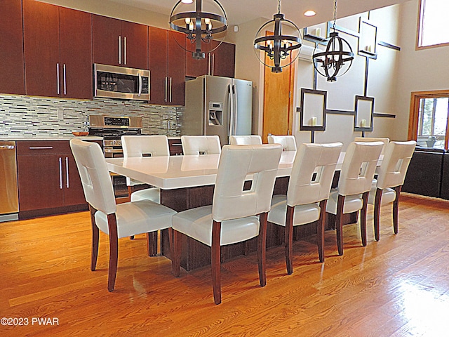 dining room with light hardwood / wood-style flooring and a chandelier