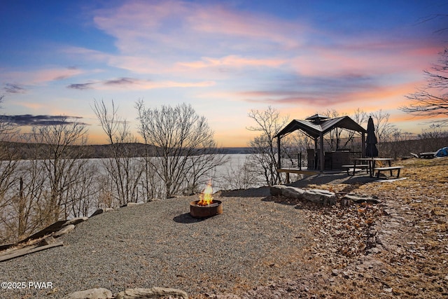 property view of water with an outdoor fire pit and a gazebo