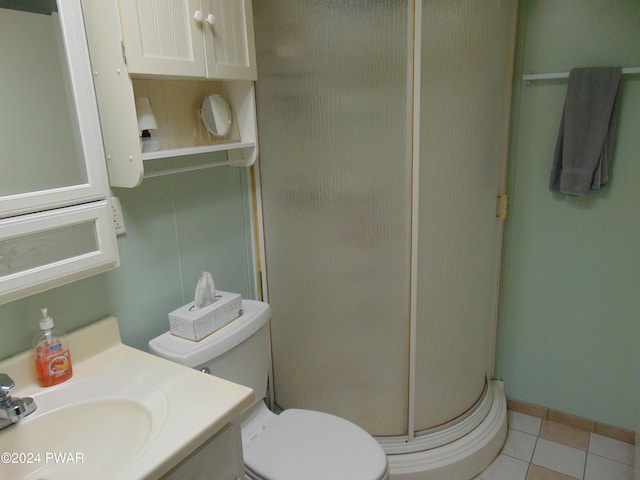 bathroom with tile patterned floors, vanity, an enclosed shower, and toilet