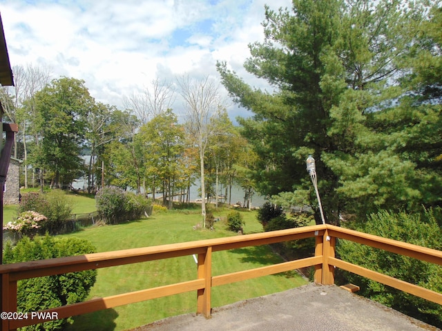 wooden terrace featuring a water view and a yard