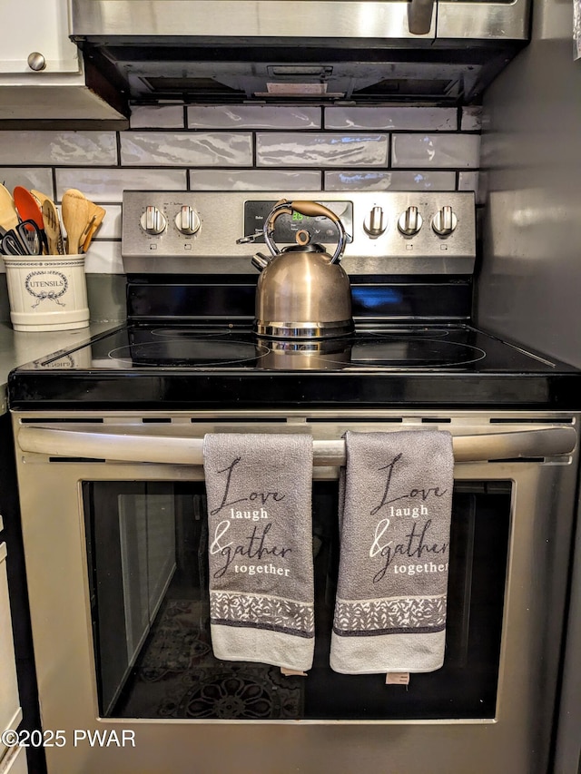 details featuring tasteful backsplash, ventilation hood, and stainless steel range with electric stovetop