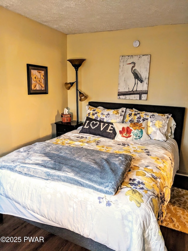 bedroom with dark hardwood / wood-style flooring and a textured ceiling