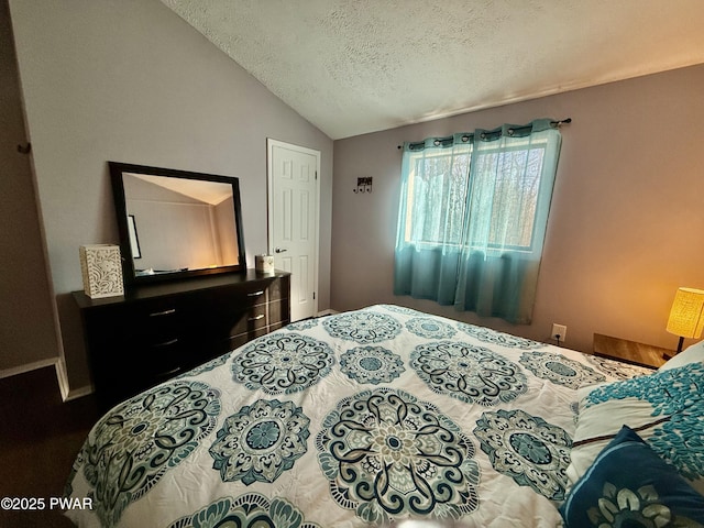 bedroom with vaulted ceiling and a textured ceiling