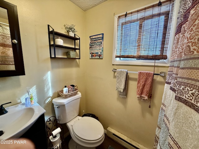 bathroom featuring a textured ceiling, toilet, and baseboard heating