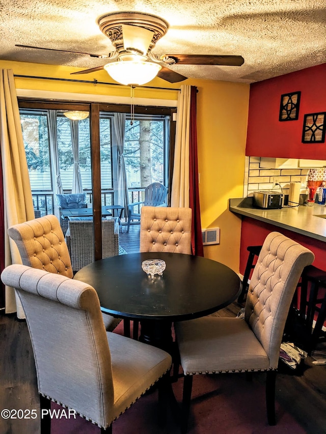 dining area with wood-type flooring, a textured ceiling, and ceiling fan