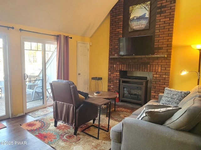 living room with vaulted ceiling, wood-type flooring, and a fireplace