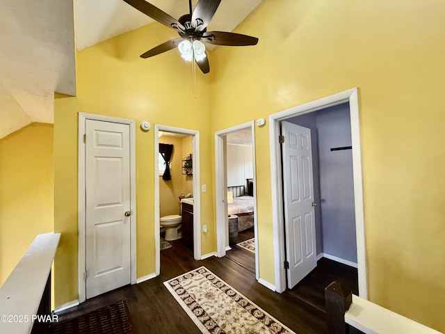 bedroom with connected bathroom, high vaulted ceiling, dark hardwood / wood-style floors, and ceiling fan