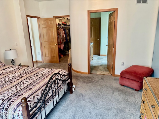 bedroom with a closet, carpet floors, visible vents, baseboards, and a spacious closet