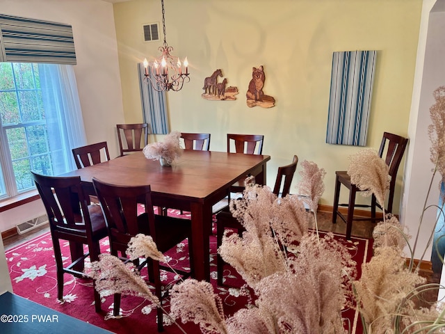 dining area with a chandelier, visible vents, and baseboards
