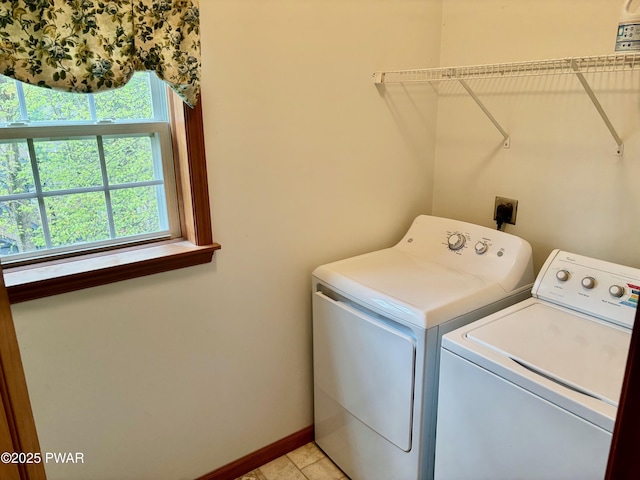 clothes washing area with laundry area, washer and clothes dryer, and baseboards