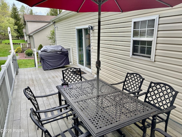 wooden deck featuring outdoor dining area and a grill