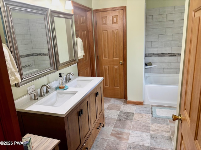 full bathroom featuring double vanity, baseboards, stone finish floor, and a sink