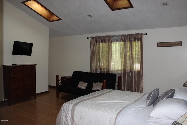 bedroom with hardwood / wood-style floors and lofted ceiling with skylight