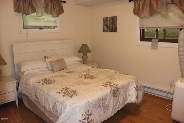 bedroom with dark hardwood / wood-style flooring and a baseboard radiator