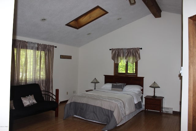 bedroom with baseboard heating, dark hardwood / wood-style flooring, and vaulted ceiling with skylight