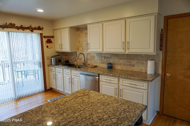 kitchen featuring dishwasher, white cabinetry, wood finished floors, and a sink