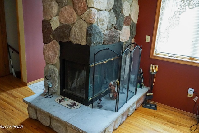 room details with baseboards, wood finished floors, and a fireplace