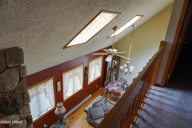 living area featuring plenty of natural light, a textured ceiling, lofted ceiling with skylight, and an inviting chandelier