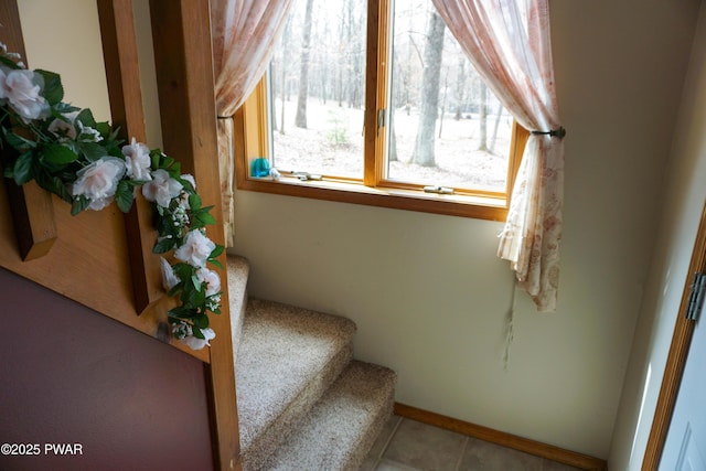 staircase featuring tile patterned floors and baseboards