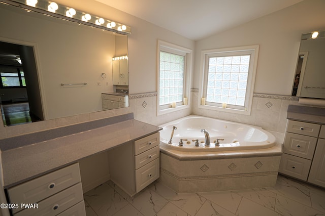 1111 Advent Rd, Lake Ariel, PA 18436 - bathroom with plenty of natural light, marble look tile flooring, vanity, vaulted ceiling, and a jetted tub