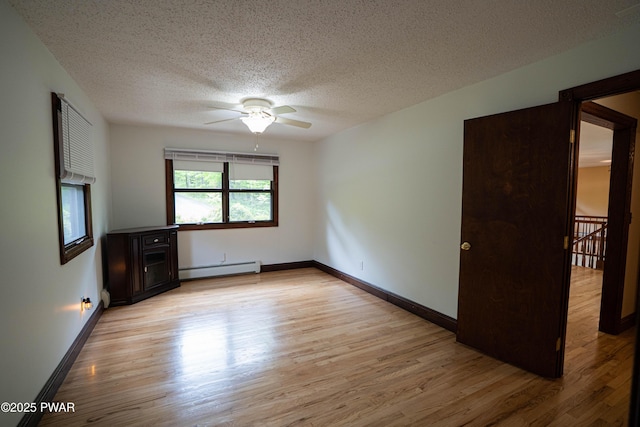 1111 Advent Rd, Lake Ariel, PA 18436 - empty room with wood finished floors, a textured ceiling, a baseboard heating unit, a ceiling fan, and baseboards