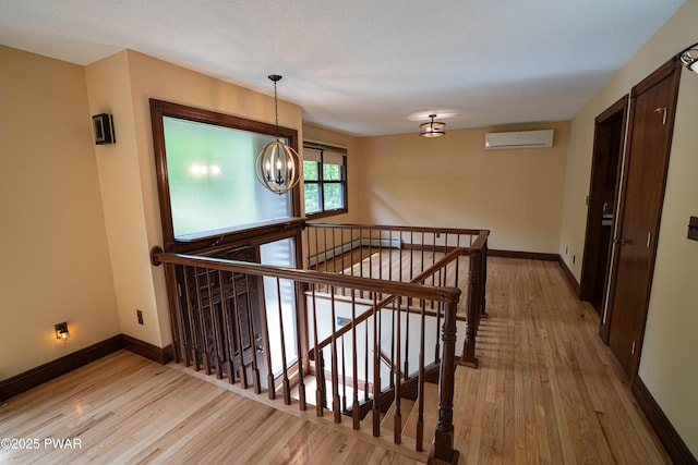 1111 Advent Rd, Lake Ariel, PA 18436 - staircase with a wall mounted air conditioner, wood finished floors, a chandelier, and baseboards