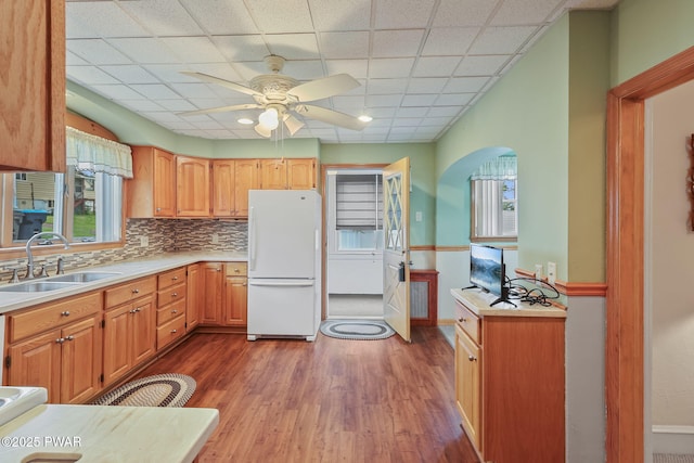 132 Dundaff St, Forest City, PA 18421 - kitchen featuring freestanding refrigerator, arched walkways, wood finished floors, ceiling fan, and backsplash