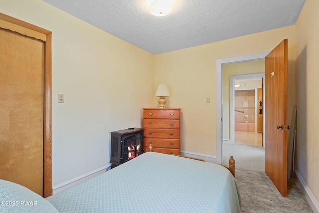 132 Dundaff St, Forest City, PA 18421 - carpeted bedroom with a textured ceiling and a wood stove